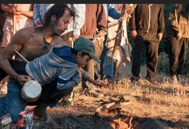 A man holds a child in a gathering of men.