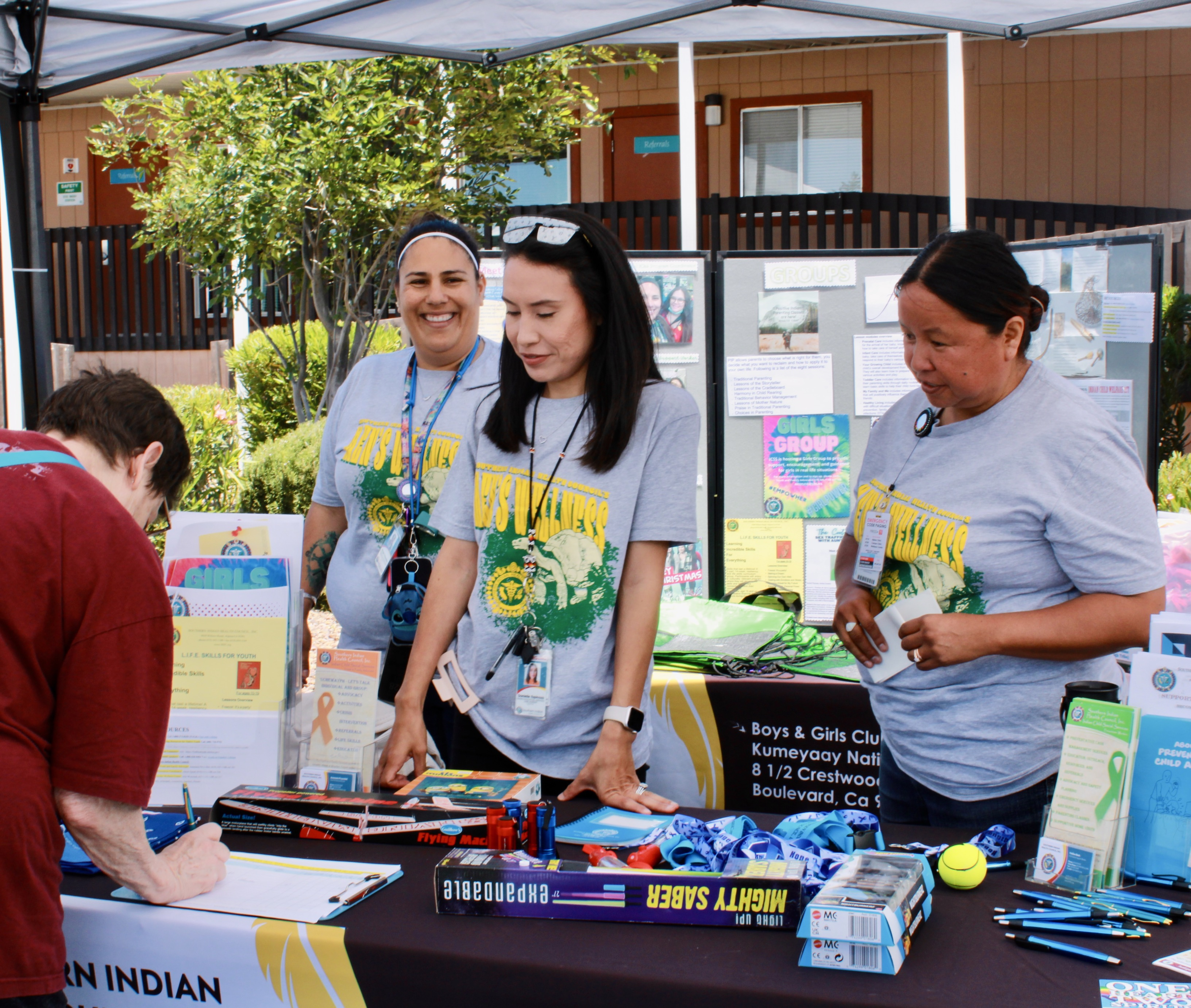 SIHC representatives engage community. A man signs up for more information.